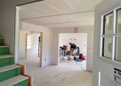 image of man in room preparing blueboard wall for painting